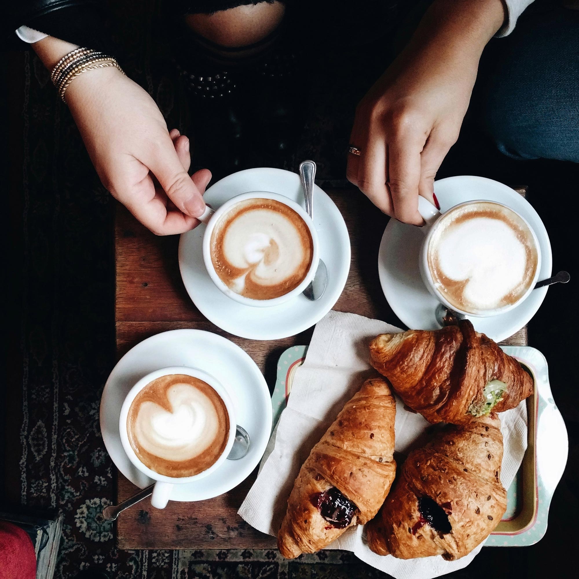 Personer fikar kaffe latte och croissanter på ett café