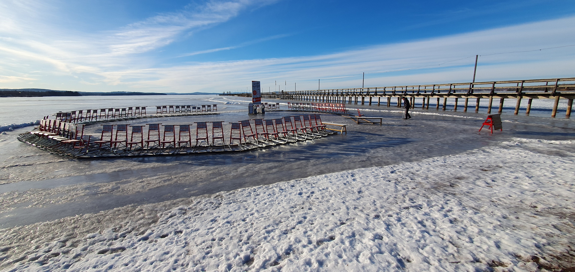 Vy över Långbryggan i Rättvik, med sparkar stående i en cirkel på isen.