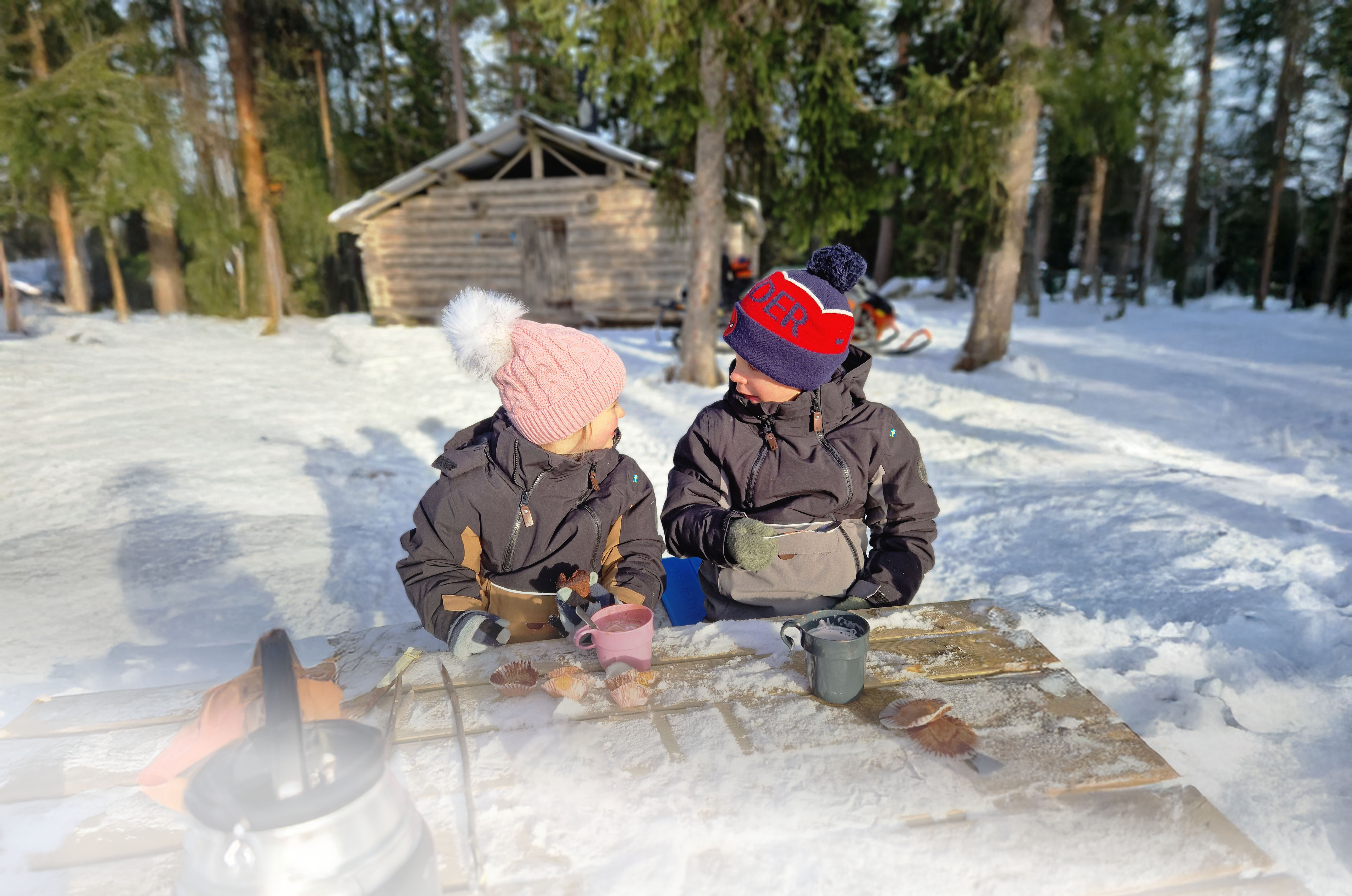 Barn, vinter och snö vid slogbod.